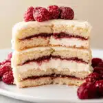 vanilla cake with raspberry filling topped with fresh raspberries