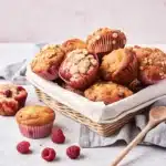raspberry muffins with crumb topping on a wooden tray