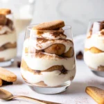 Tiramisu cups with creamy layers and cocoa topping
