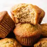 freshly baked 2 banana muffins on a wooden kitchen counter