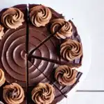 Chocolate cheesecake with ganache topping on wooden stand