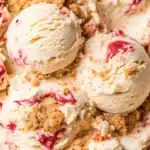 Strawberry cheesecake ice cream in waffle cone with graham crust