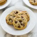Close-up of almond flour chocolate chip cookies with gooey centers and crispy edges on a white plate