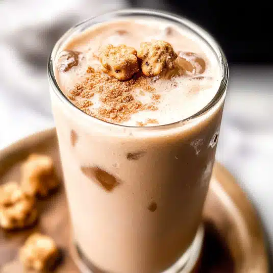 Creamy iced Teddy Graham Latte in a glass topped with crushed graham crackers and bear-shaped cookies