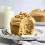 Frosted vanilla cupcake with creamy peanut butter cream cheese frosting topped with chopped peanuts