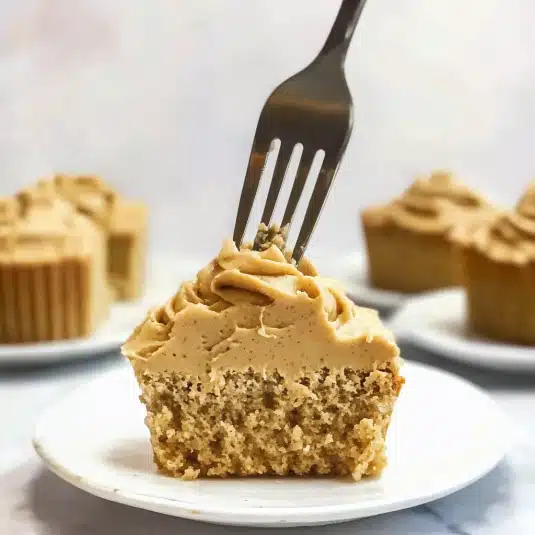 Half-eaten cupcake topped with piped peanut butter cream cheese frosting and a fork