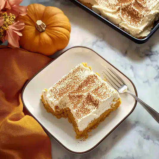 pumpkin tres leches cake topped with whipped cream and cinnamon